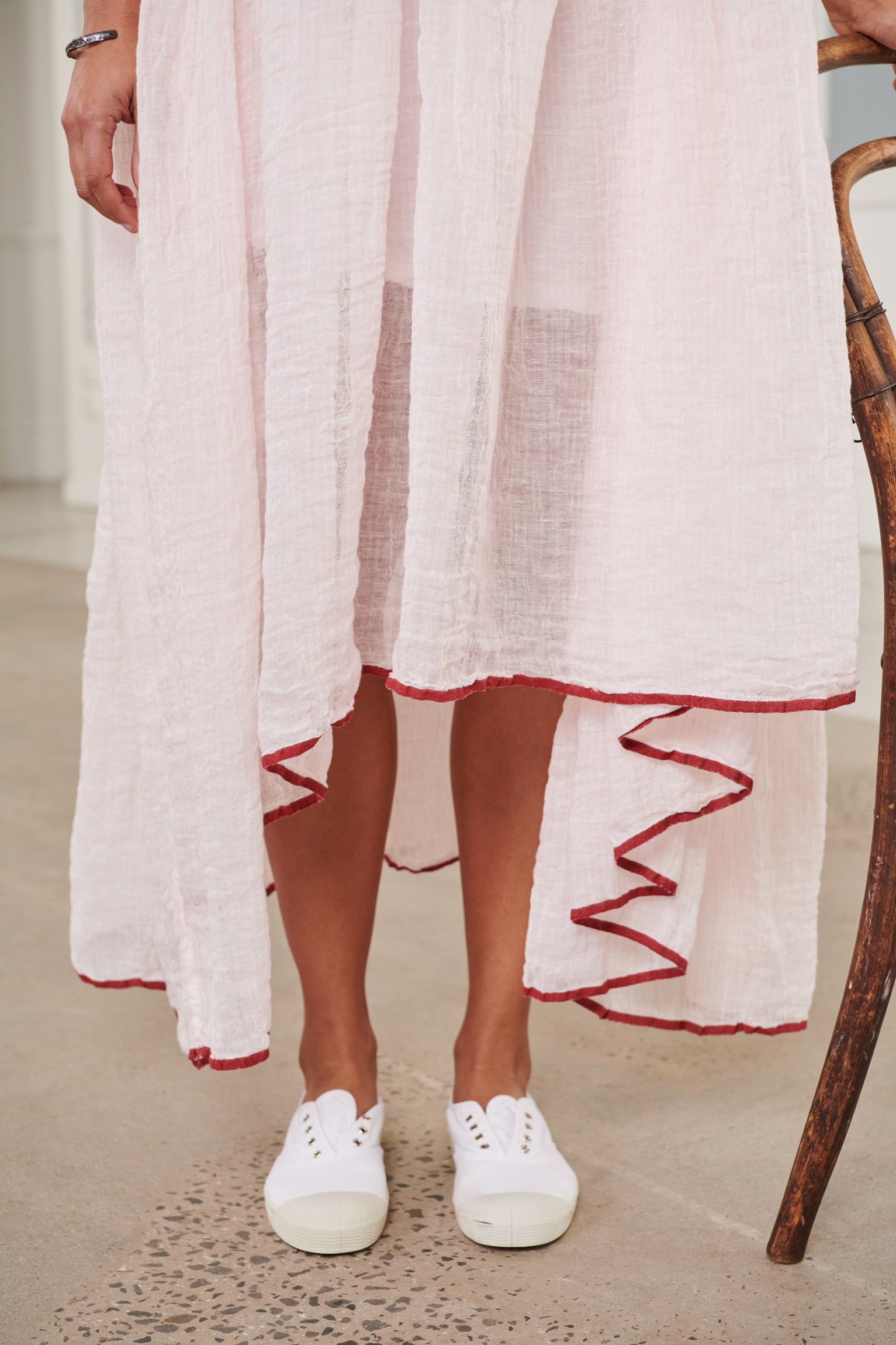 A MegbyDesign model is wearing a pink soft gauze linen tunic dress with a red trim