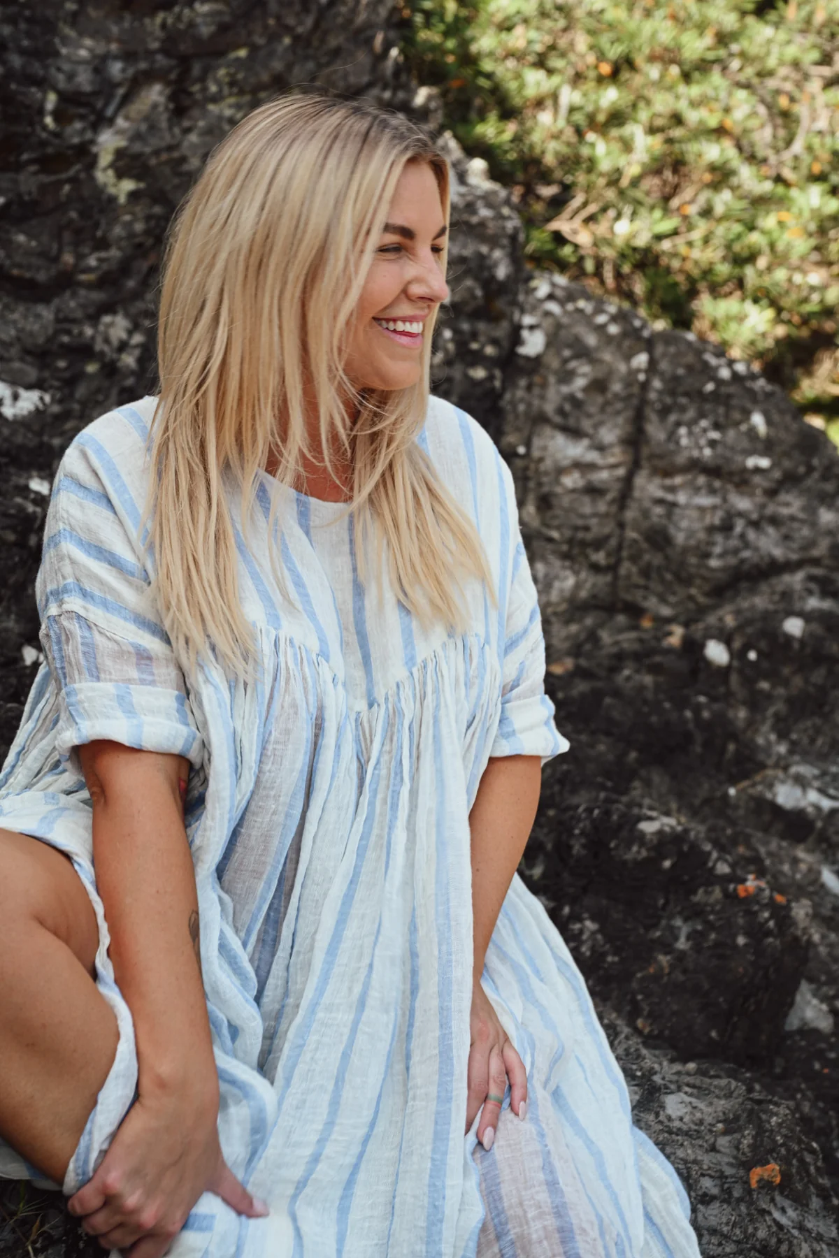 A MegbyDesign model is wearing a blue and white striped soft gauze linen tunic dress