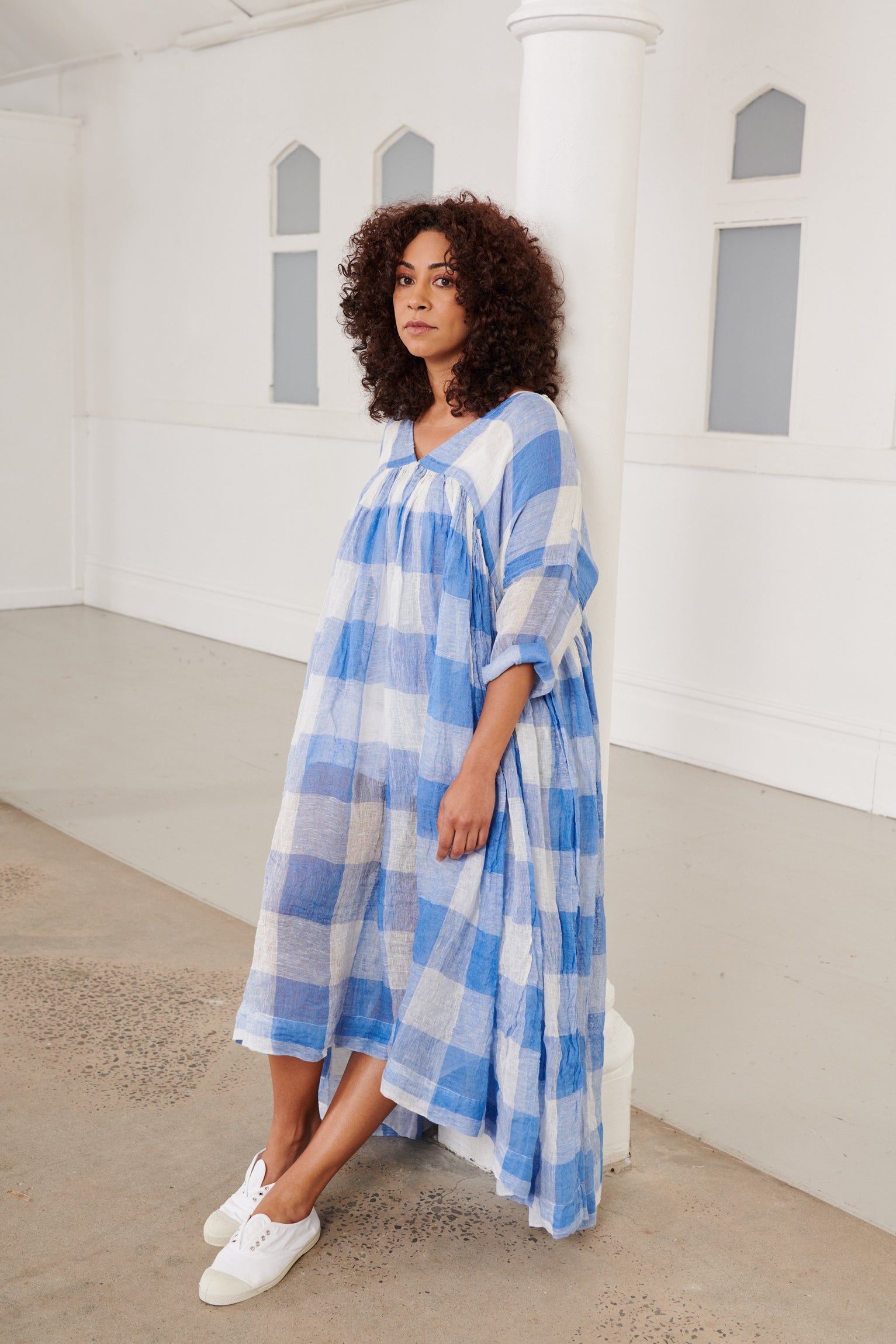 A MegbyDesign model is wearing a blue and white gingham soft gauze linen tunic dress