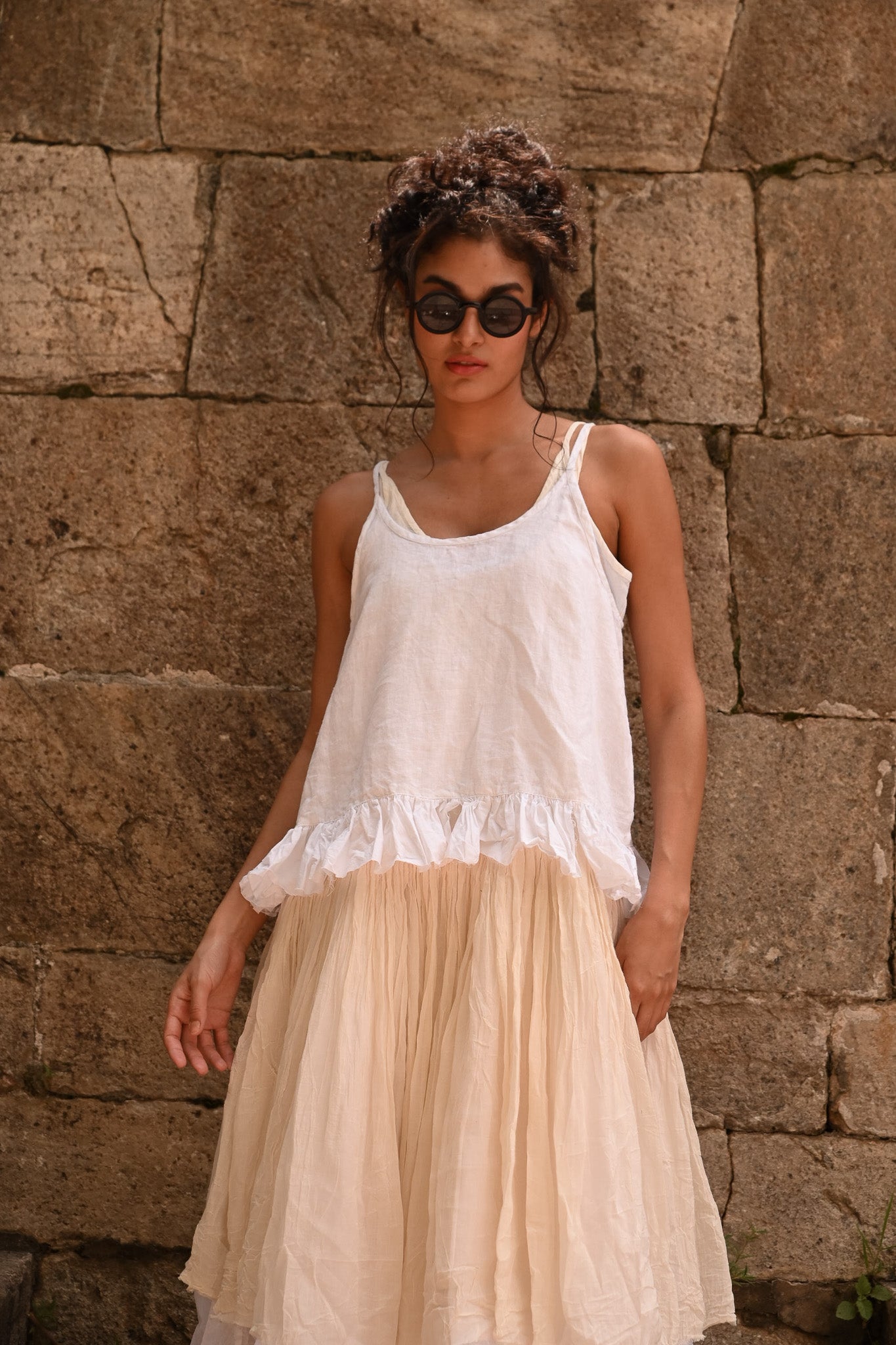 A MegbyDesign model is wearing a white elisa cami made from a lightweight cotton material and the straps are adjustable.