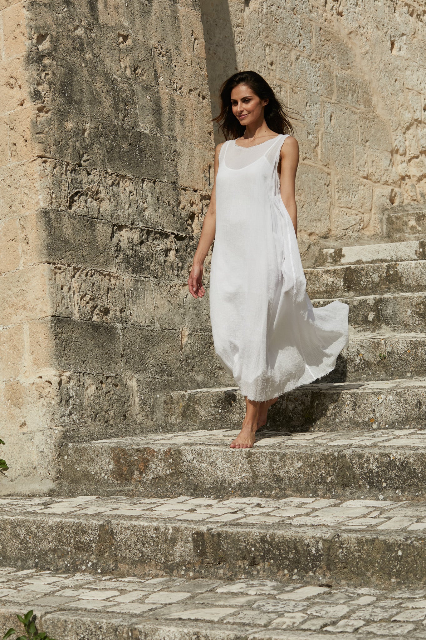 A MegbyDesign model is wearing a white gauze cotton angelica dress. The white angelica dress is made from a beautifully lightweight gauze cotton.