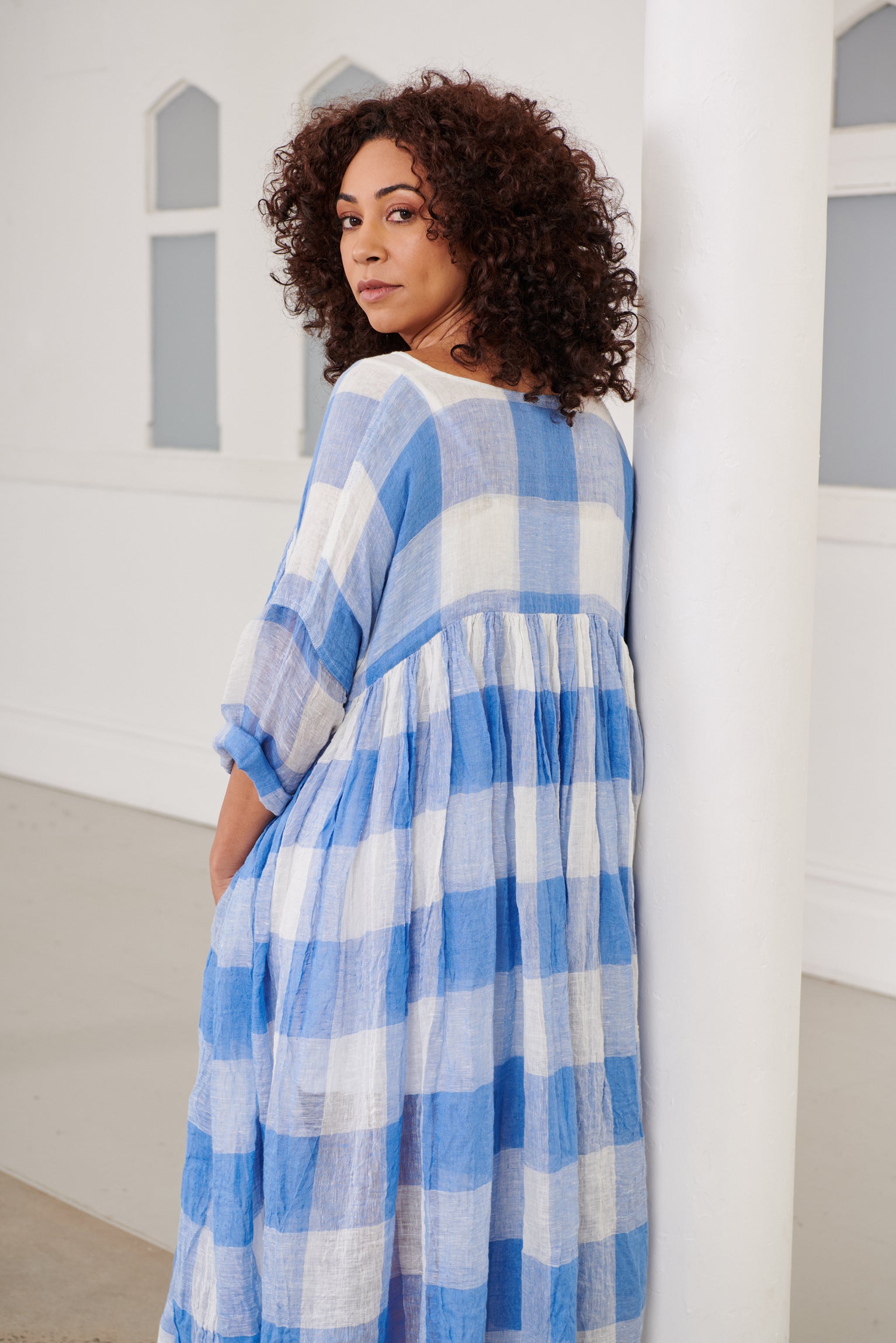 A MegbyDesign model is wearing a blue and white gingham soft gauze linen tunic dress
