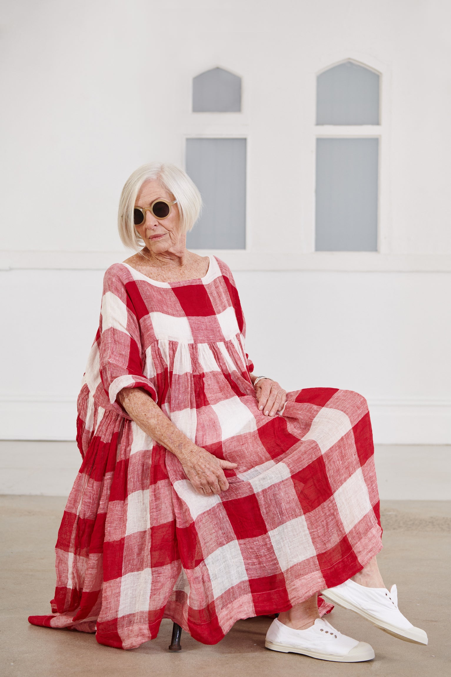 A MegbyDesign model is wearing a red and white gingham soft gauze linen tunic dress