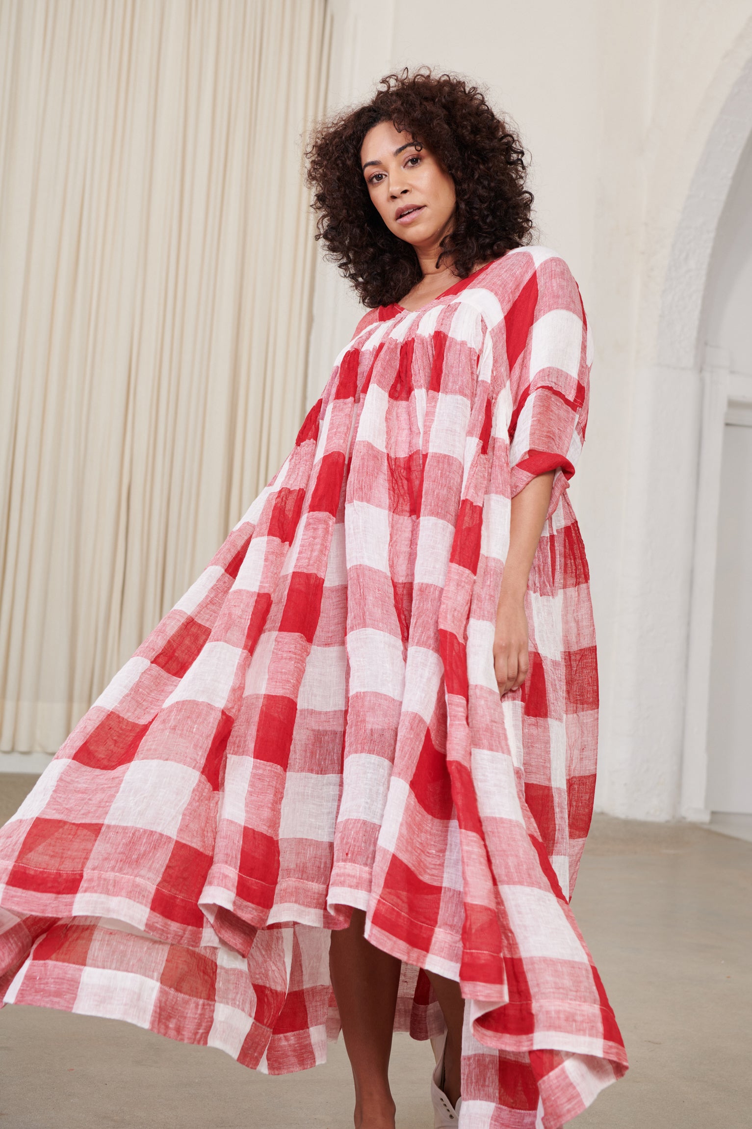 A MegbyDesign model is wearing a red and white gingham soft gauze linen tunic dress