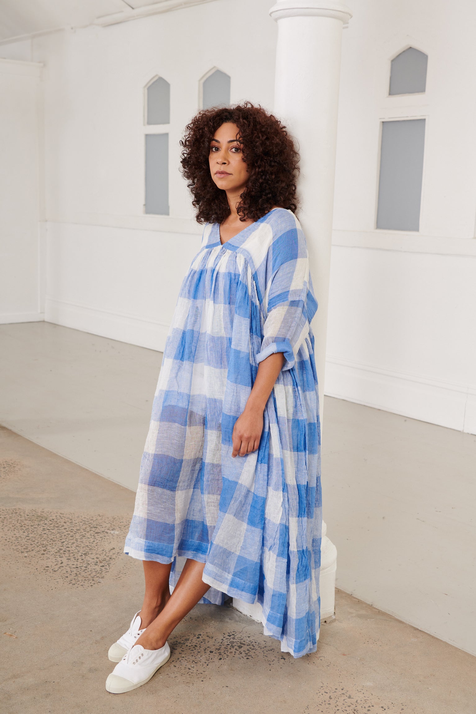 A MegbyDesign model is wearing a blue and white gingham soft gauze linen tunic dress 