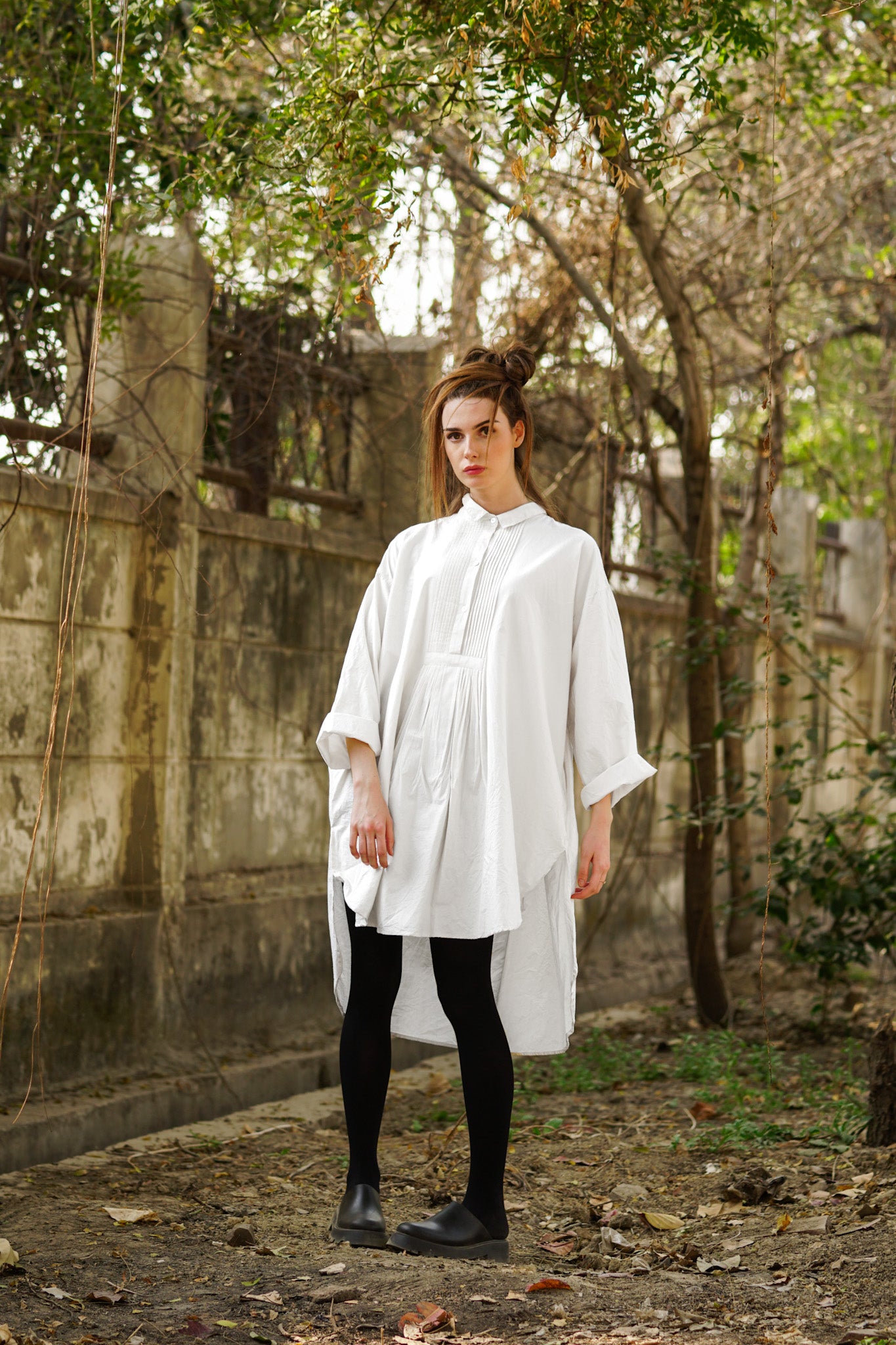 A MegbyDesign model is wearing a white cotton twill oversized dress shirt with a crisp crumpled texture