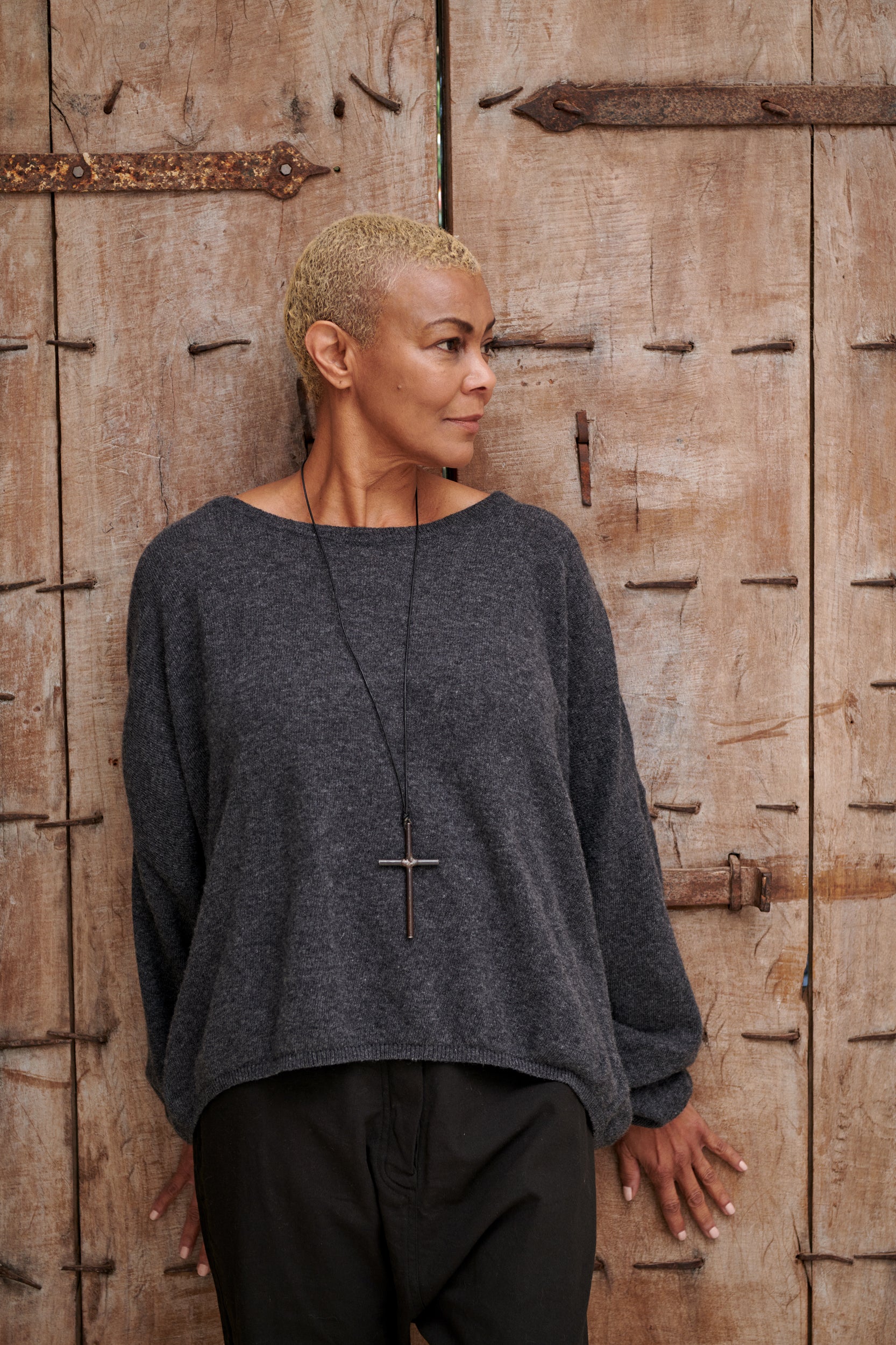 A MegbyDesign model is wearing a charcoal woollen thread sweater with two pockets and an oversized fit 