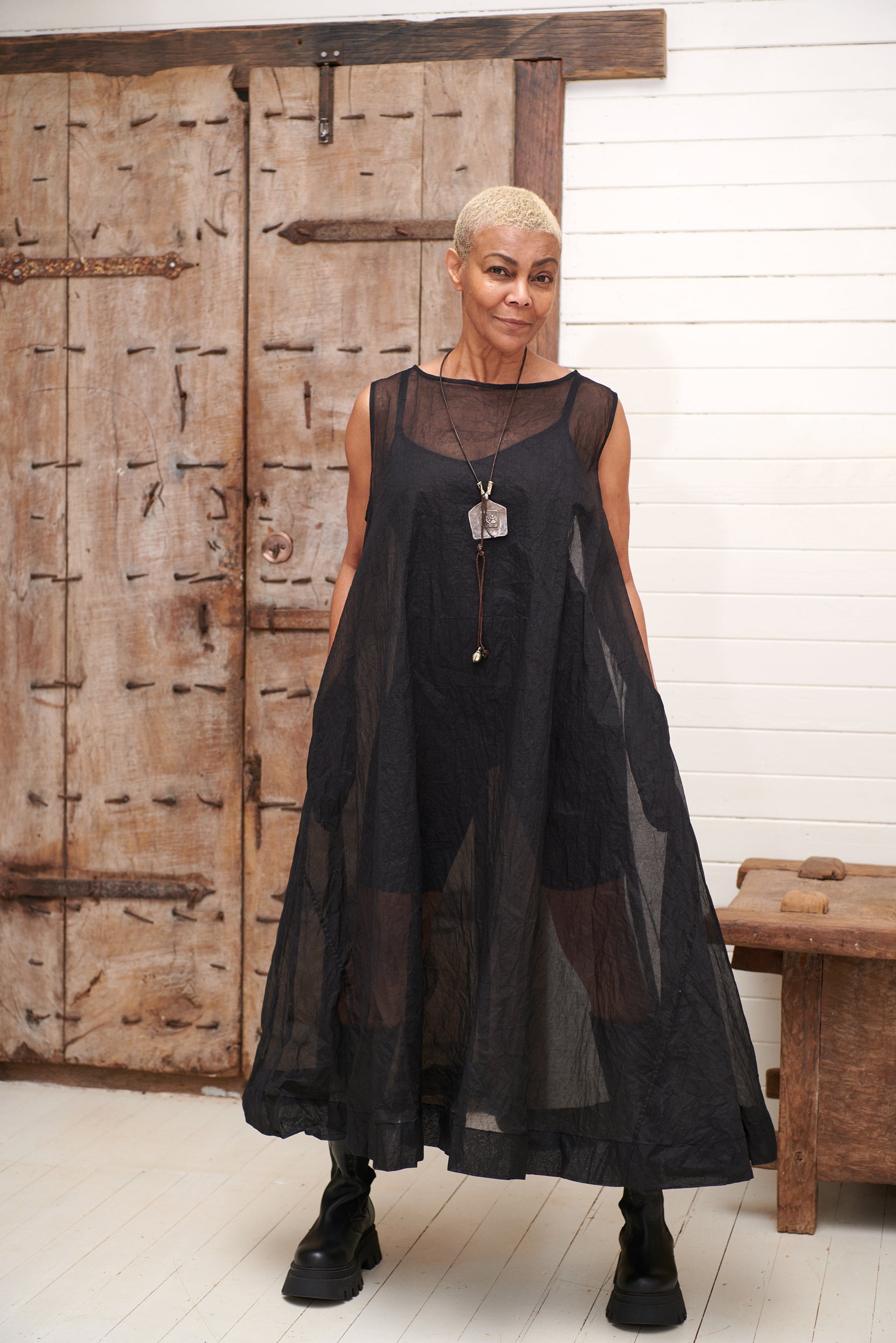 A MegbyDesign model is wearing a black A line dress made from a sheer cotton organza